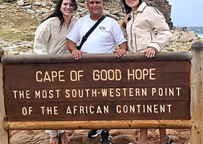 Group of tourists posing at Cape of Good Hope sign in Cape Town
