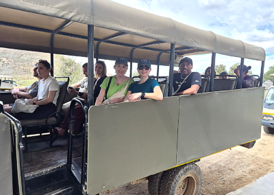 Tourists seated in an open safari vehicle during a Cape Town group tour