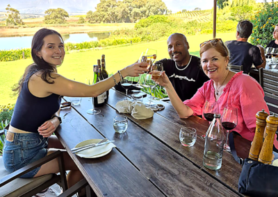 Tourists enjoying wine tasting and dining at a Cape Town wine estate with mountain views Caption