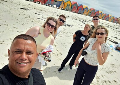 Group of tourists at Muizenberg Beach Cape Town with colorful huts